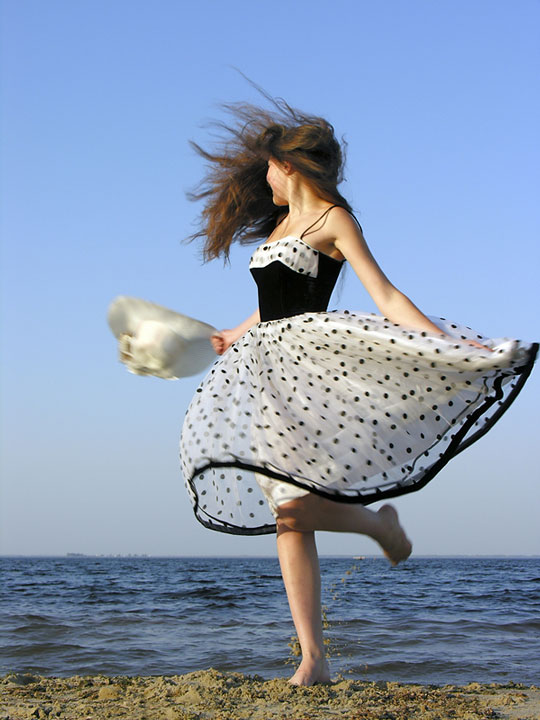 woman wearing a dress on a windswept beach